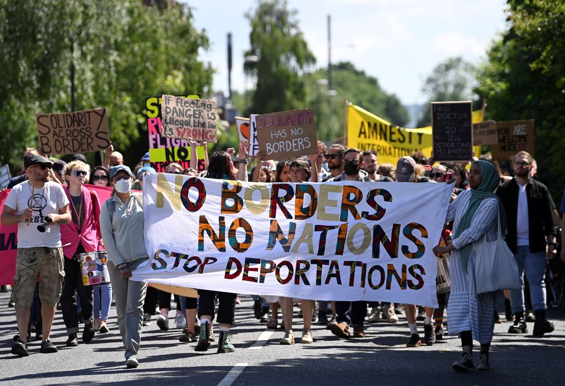 Demonstrators protest outside of an airport perimeter fence against a planned deportation of asylum seekers from the UK to Rwanda, at Gatwick Airport on June 12, 2022.