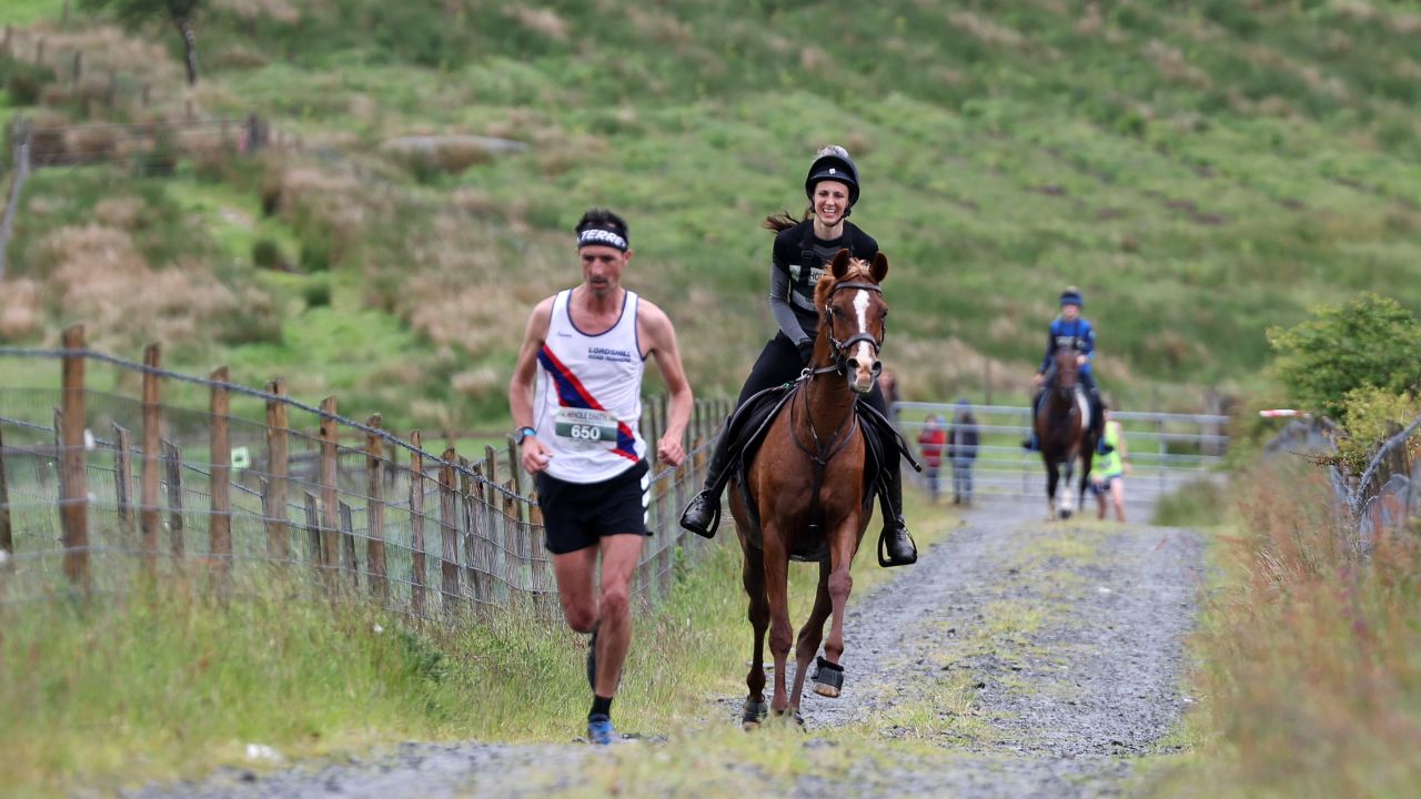 Runners compete against horses and their riders at the race on Saturday, which was staged after a two-year absence due to the coronavirus pandemic.