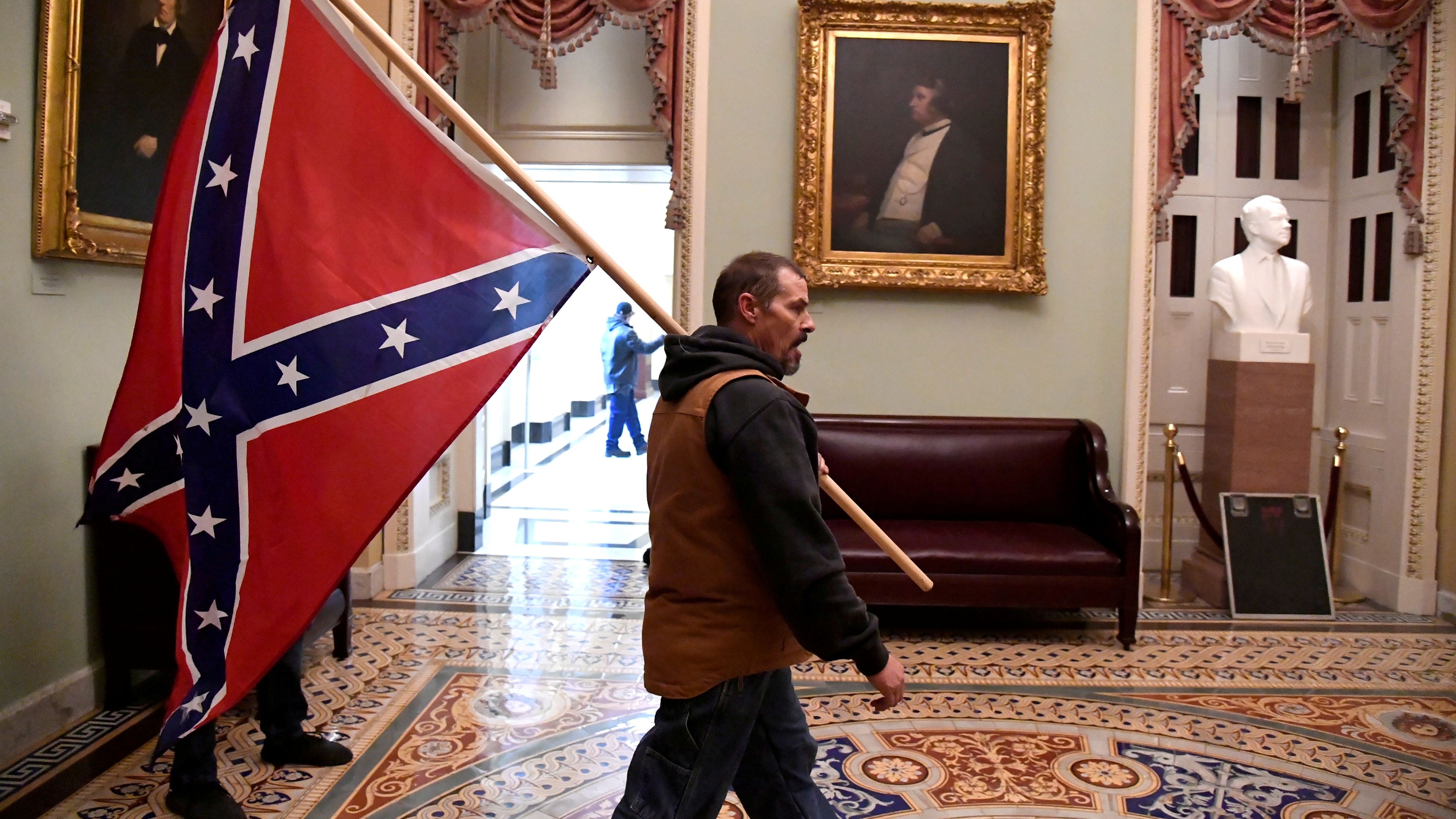 Kevin Seefried carries a Confederate battle flag on the second floor of the US Capitol on January 6, 2021. 