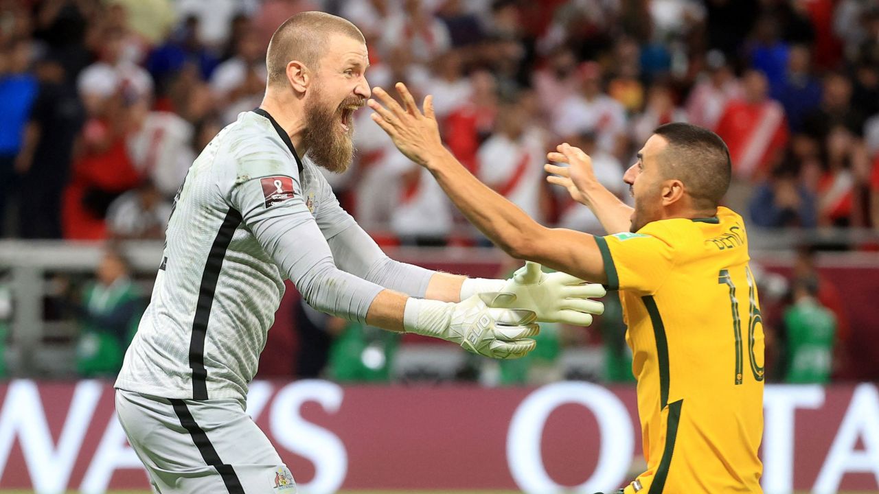 Australia's Andrew Redmayne and teammate Aziz Behich celebrate after qualifying for the FIFA World Cup on June 13.