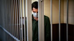 TOPSHOT - US ex-marine Trevor Reed, charged with attacking police, stands inside a defendants' cage during his verdict hearing at Moscow's Golovinsky district court on July 30, 2020. - A Russian court on February 10, 2021 ordered a psychological examination of former US Marine Trevor Reed, who was convicted of assaulting a police officer in a case condemned by President Joe Biden's administration. Reed, 29, was found guilty and sentenced to nine years behind bars in July last year for allegedly hitting a Moscow law enforcement officer while drunk in 2019. (Photo by Dimitar DILKOFF / AFP) (Photo by DIMITAR DILKOFF/AFP via Getty Images)