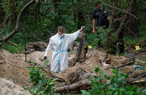 A forensic technician inspects a mass grave near the village of Vorzel in the Bucha district near Kyiv, Ukraine, on June 13.