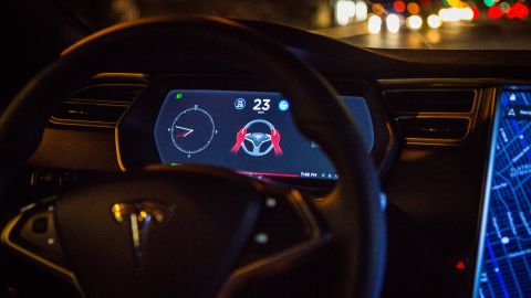 A Tesla dashboard is shown as the Autopilot software disengages during a drive in Brooklyn, New York.