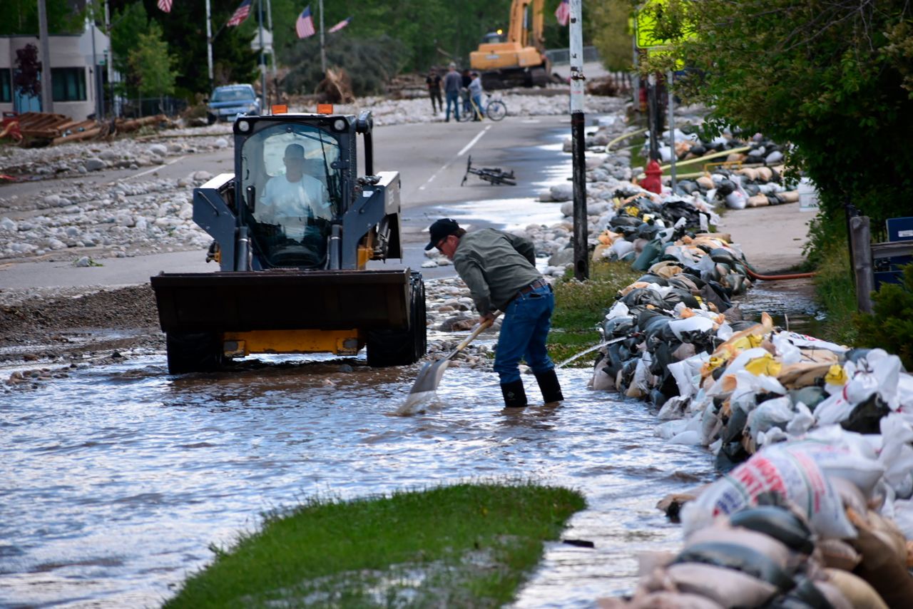 Red Lodge residents clear mud, water and debris on Tuesday.