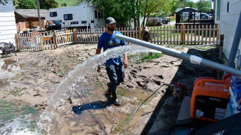 Micah Hoffman uses a pump to remove water from his basement in Rod Lodge, Montana.