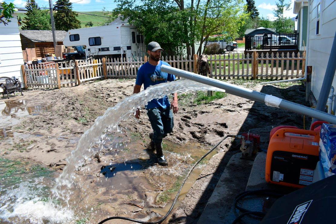 Micah Hoffman uses a pump to remove water from his basement in Red Lodge, Montana.