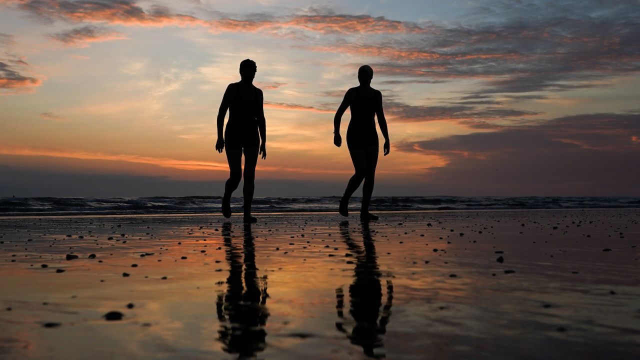 Swimmers walk back from the sea after a summer solstice dip in Saltburn-by-the-Sea, England, on June 21, 2021.