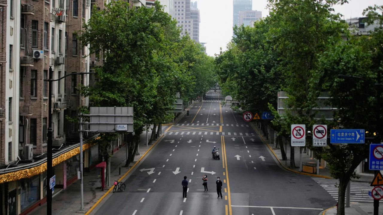 People stand on an empty street during lockdown in Shanghai, May 26, 2022. 