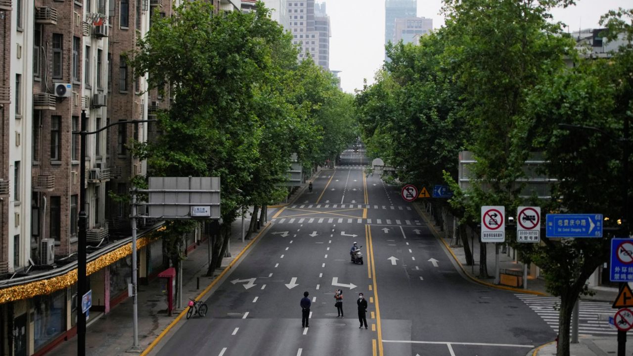 People stand on an empty street during lockdown in Shanghai, May 26, 2022.