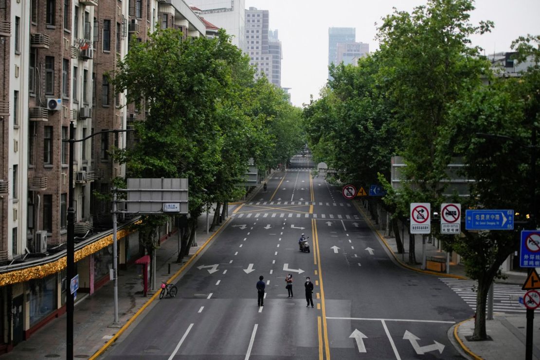 People stand on an empty street during lockdown in Shanghai, May 26, 2022. 