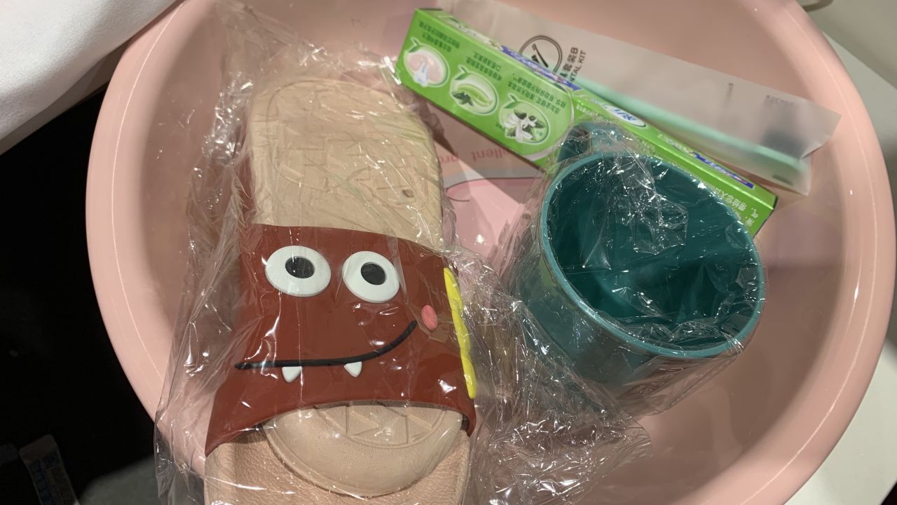 A welcome pack including bedding, a plastic basin, a cup for washing, a toothbrush, toothpaste, towel and slippers.