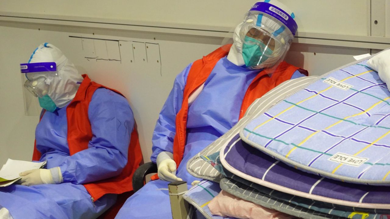 Volunteers in hazmat suits take a nap inside Shanghai's biggest government Covid-19 quarantine center.