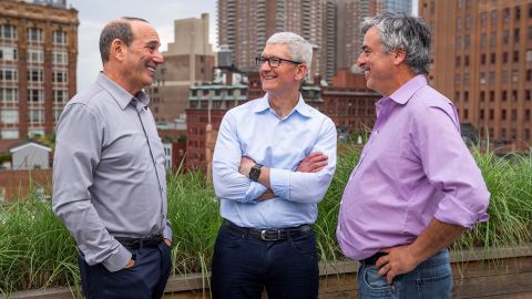 Major League Soccer commissioner Don Garber, left, Apple CEO Tim Cook, center, and Apple senior vice president of Services Eddy Cue talk in New York, June 8, 2022.
