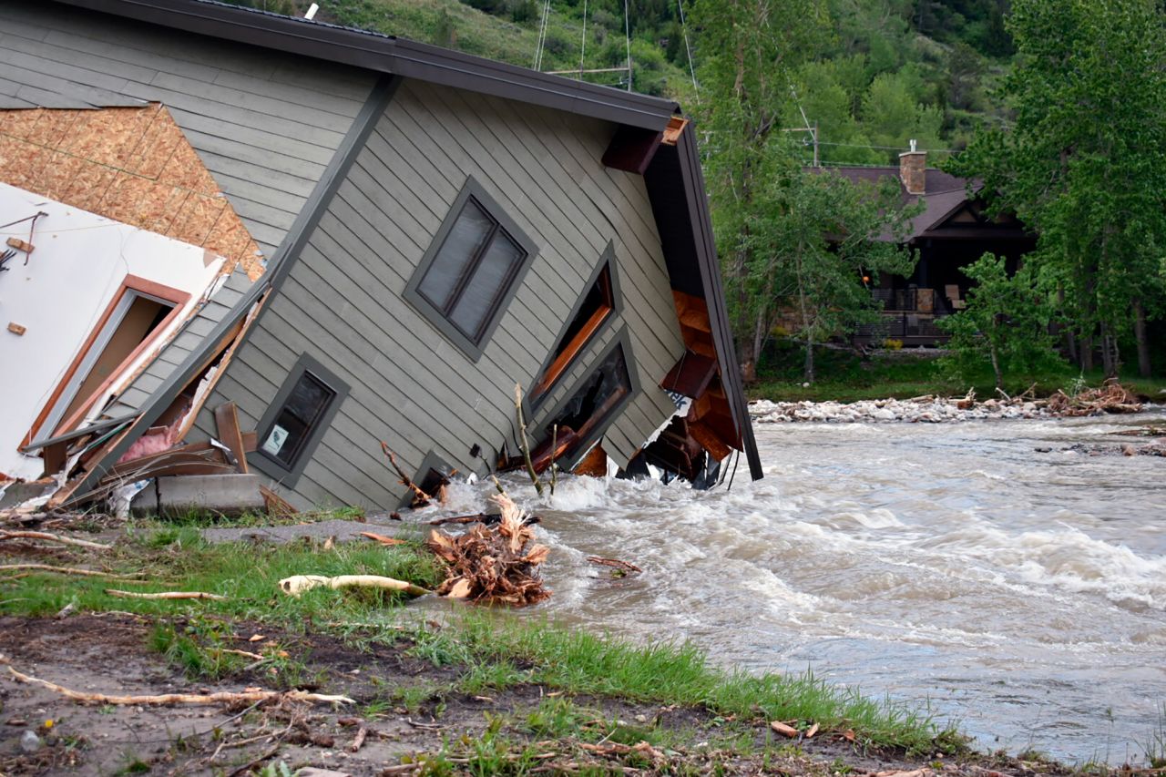 A damaged home sits in floodwaters in Red Lodge on Tuesday. <br />