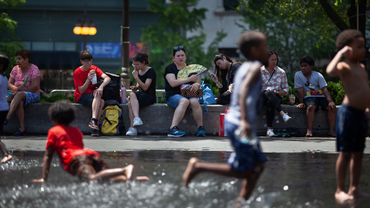 Children play outside in downtown Chicago on Tuesday. Temperatures and heat indices have soared to triple digits this week in the Midwest and Southeast.