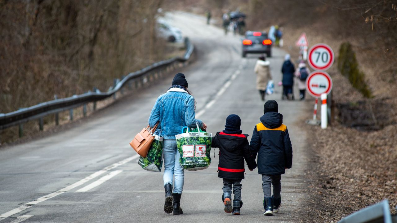 A woman with two children leaves Ukraine on foot February 25, crossing the Slovak-Ukrainian border following Russia's invasion of Ukraine. 