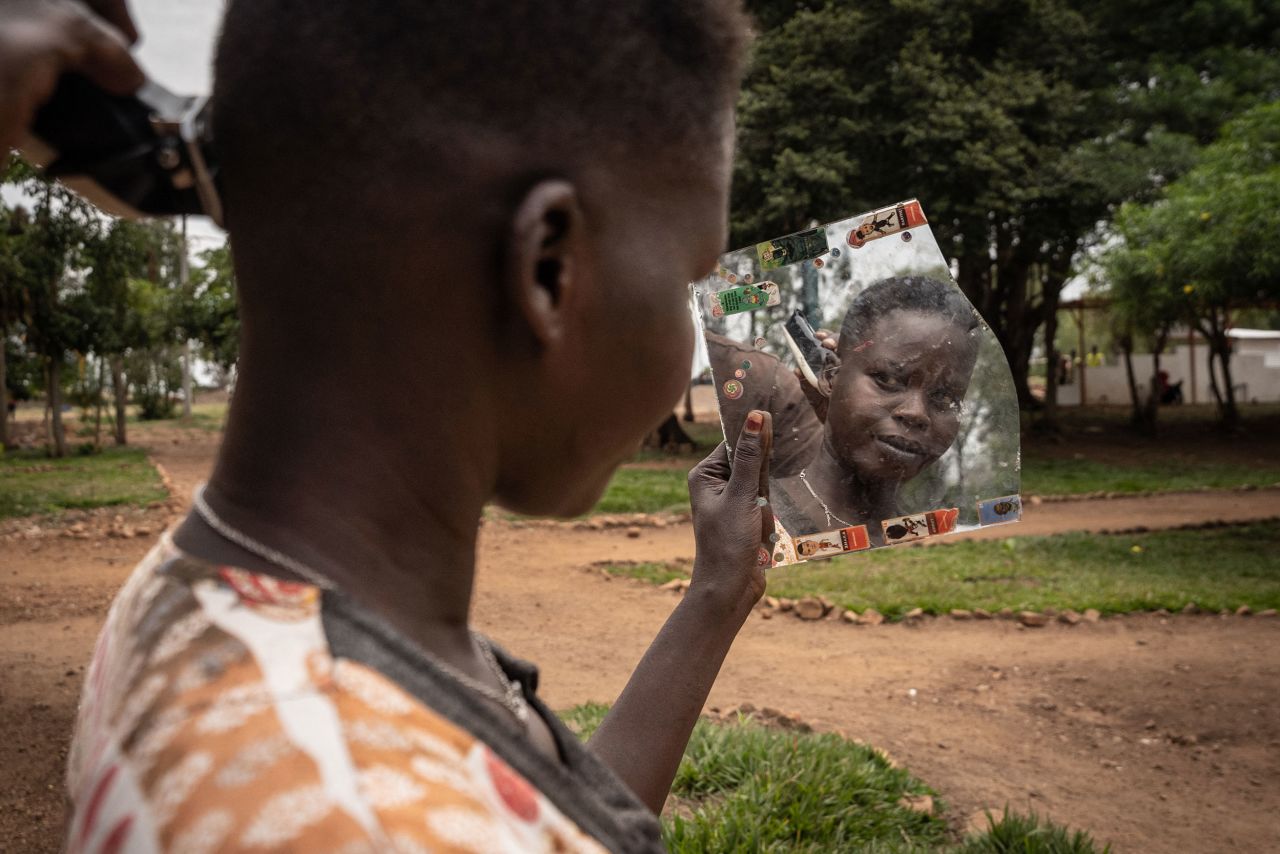 Nyalada Gatkouth Jany, an asylum seeker from South Sudan who has tried to cross the Mediterranean Sea four times, gets her hair cut at a transit center in Gashora, Rwanda, on Friday, June 10.