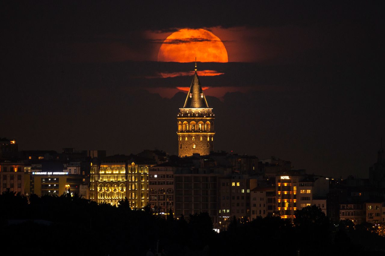 A full moon rises behind the Galata Tower in Istanbul on Tuesday, June 14. This year's <a href="https://www.cnn.com/2022/06/13/world/strawberry-full-moon-june-2022-scn/index.html" target="_blank">strawberry moon</a> is the first of two consecutive supermoons.