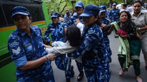 Indian security personnel detain a demonstrator during protests in New Delhi on Thursday against the government's new military recruitment scheme.