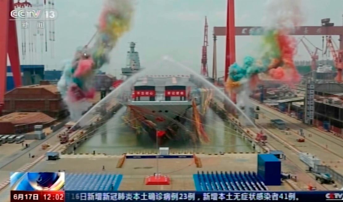 In this image taken from China's state broadcaster CCTV, water cannons spray China's third aircraft carrier Fujian during its launching ceremony at a dry dock in Shanghai on Friday.