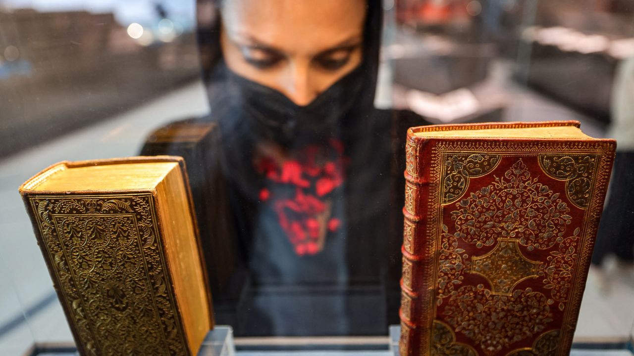 A visitor views a 1644 manuscript copy of the "Sacred Prayers of the Christian Soul" by Pierre Moreau (R) on display at the newly-opened Mohammed Bin Rashid library (MBRL) in Dubai on June 16.