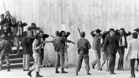 L'armée colombienne protège un groupe de magistrats quittant le palais de justice de Bogota le 6 novembre 1985. 