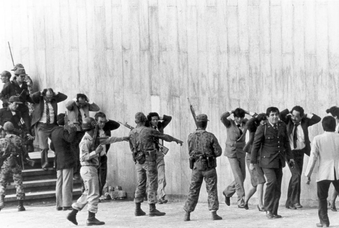 Colombian military protect a group of magistrates leaving the Palace of Justice in Bogota on November 6, 1985. 