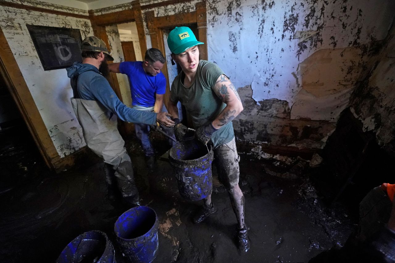 Volunteers clean out a flooded basement in Red Lodge on Thursday.