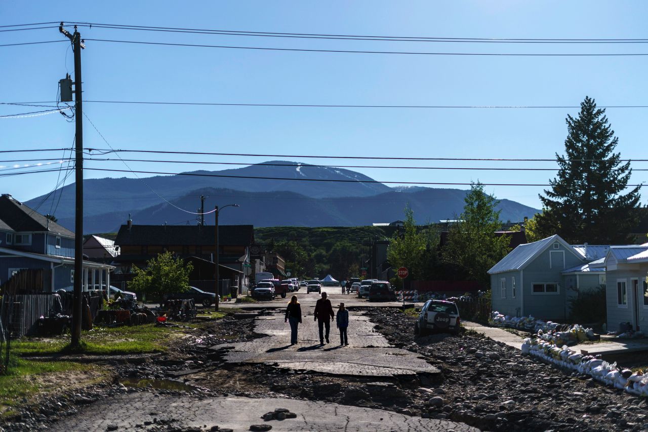 Pedestrians walk down a damaged street in Red Lodge on June 15. 