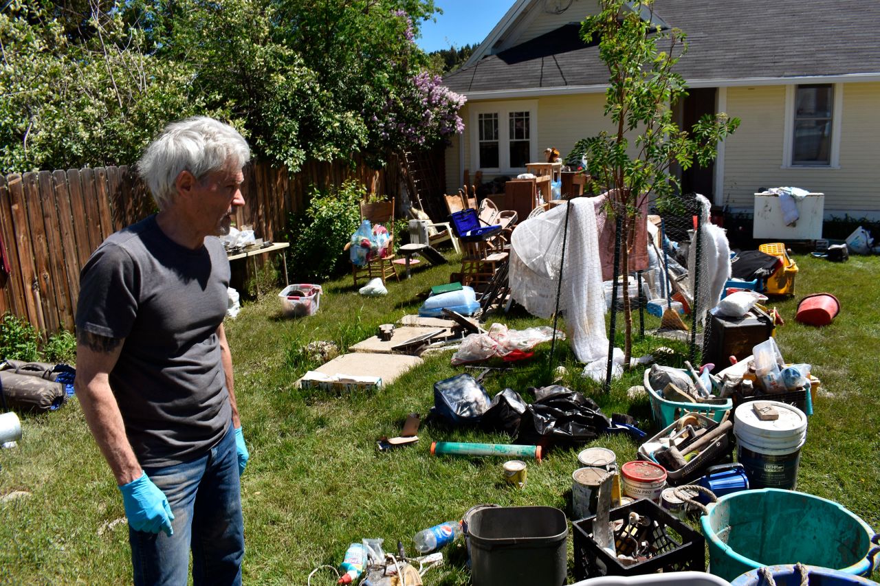 Thomas Smith looks over belongings from his flooded basement in Red Lodge on Thursday.