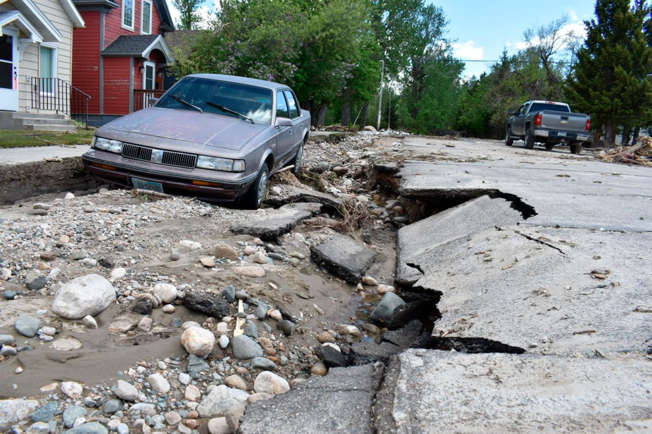 A car sits on a damaged street in Red Lodge on Tuesday. 