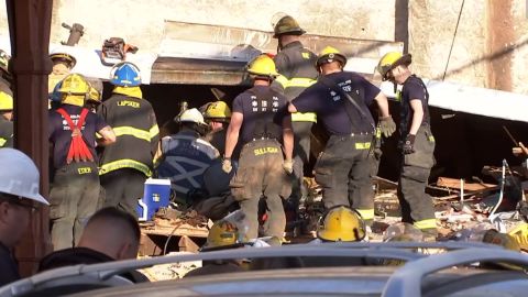 Firefighters comb through the rubble.