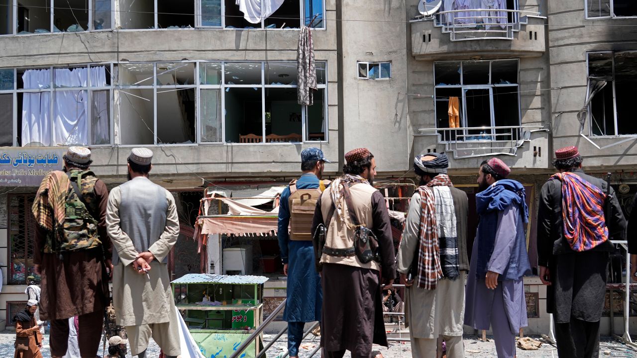 Taliban fighters gather at the site of an explosion in front of a Sikh temple in Kabul on Saturday.