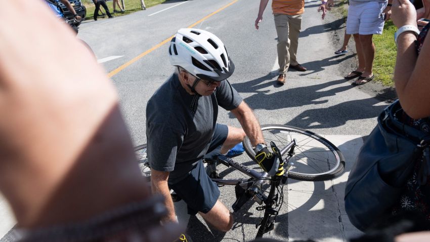 US President Joe Biden falls off his bicycle as he approaches well-wishers following a bike ride at Gordon's Pond State Park in Rehoboth Beach, Delaware, on June 18, 2022. (Photo by SAUL LOEB / AFP) (Photo by SAUL LOEB/AFP via Getty Images)