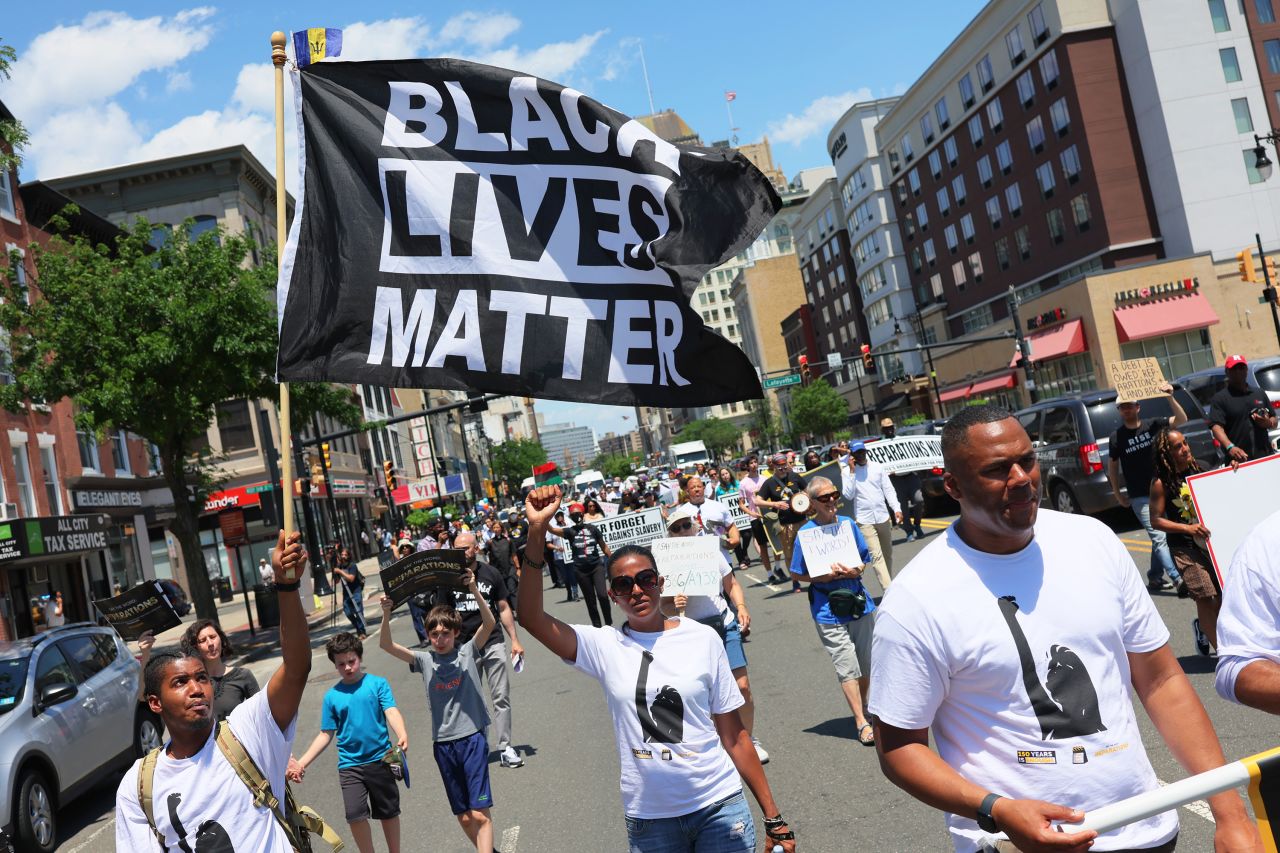 People march in a Juneteenth reparations rally in Newark, New Jersey on Friday. Rally-goers called on New Jersey lawmakers to pass legislation to establish a Reparations Task Force to propose policy for reparative justice. 