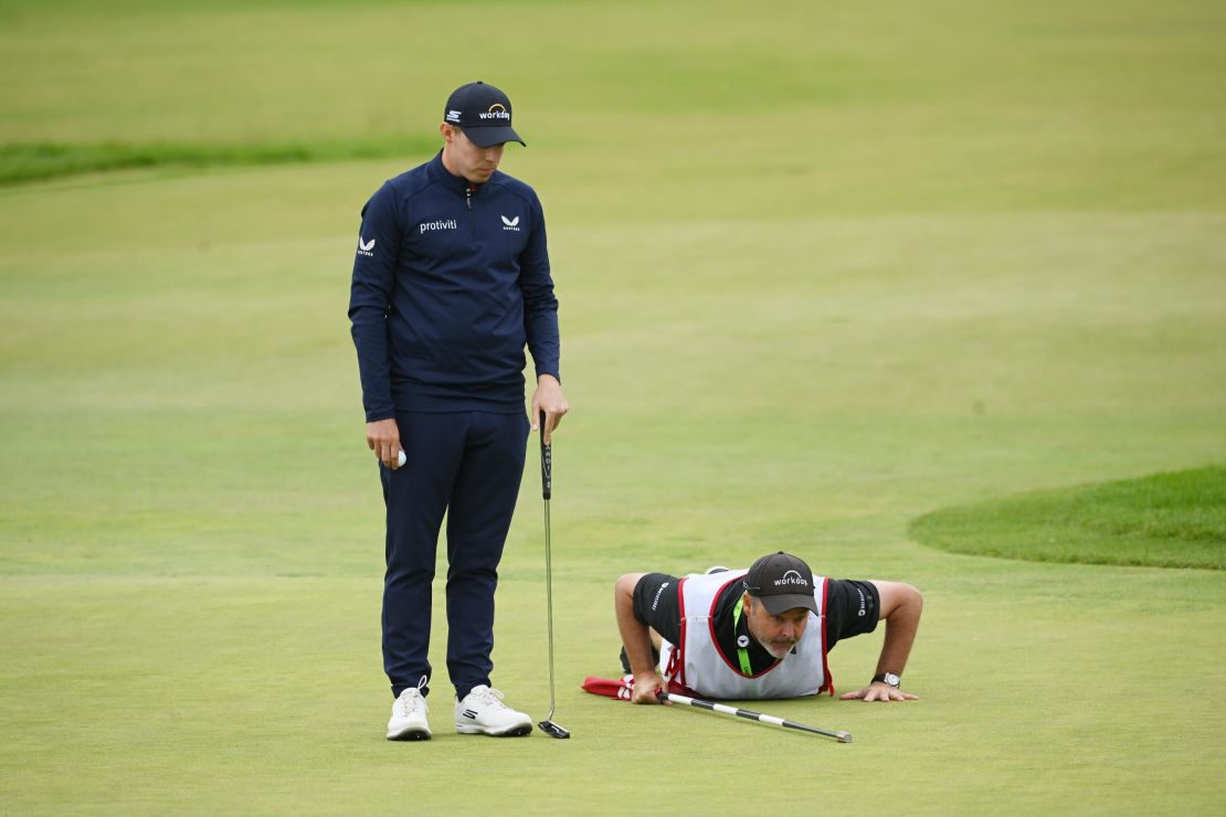Fitzpatrick and caddie Billy Foster line up a putt on the 15th green.