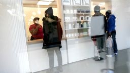 Customers pick up online orders at the Apple Store at the Towson Town Center, Tuesday, Dec. 15, 2020, in Towson, Md. The store has been remodeled to accommodate pick-up only with no in-store access to help stop the spread of COVID-19. (AP Photo/Julio Cortez)