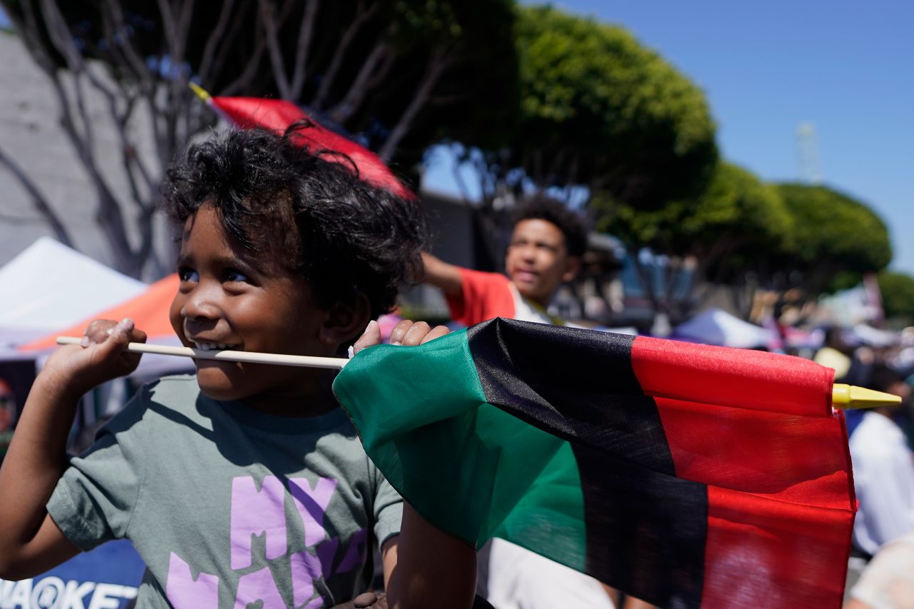 Maison James holds a Pan-African flag at a Juneteenth commemoration in Los Angeles on Saturday.