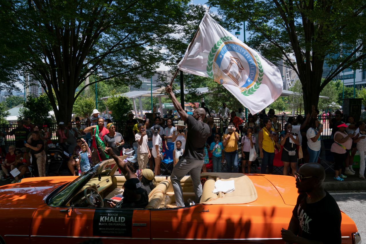 Khalid Kamau, the mayor of South Fulton, Georgia, waves a flag while appearing in a Juneteenth parade in Atlanta on Saturday.