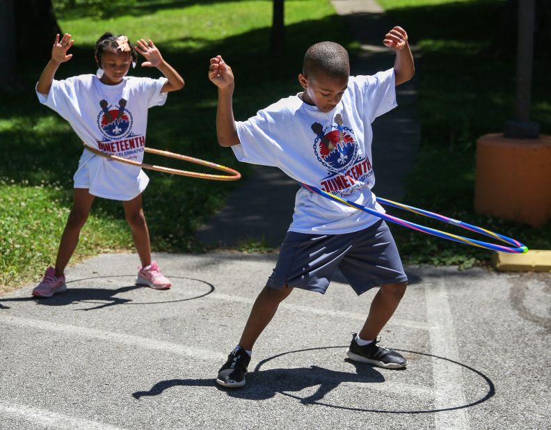 Cameron Price and his sister Emory play with hula hoops at the Juneteenth Youth Jamboree in Louisville, Kentucky, on Saturday.