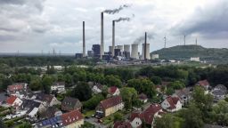 Chimneys and a cooling tower emit vapor at the Scholven coal-fired power plant, operated by Uniper SE, beyond housing in Gelsenkirchen, Germany, on Saturday, May 21, 2022. 