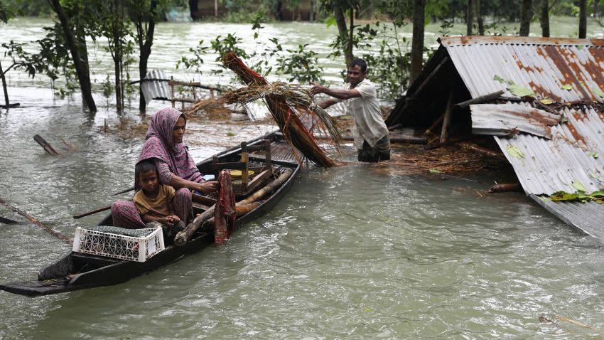 A family collects their goods  before leaving their submerged home after flash floods at Goainghat sub-distric in Sylhet, Bangladesh on June 19, 2022. Monsoon storms in Bangladesh and India have killed at least 59 people and unleashed devastating floods that left millions of others stranded, officials said. (Photo by Syed Mahamudur Rahman/NurPhoto)NO USE FRANCE