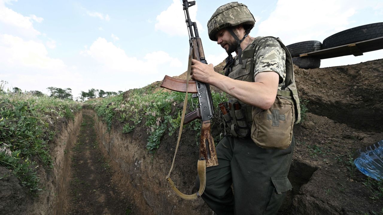 A Ukrainian serviceman walks in a trench on a position held by the Ukrainian army between southern cities of Mykolaiv and Kherson on June 12, 2022, amid the Russian invasion of Ukraine. 