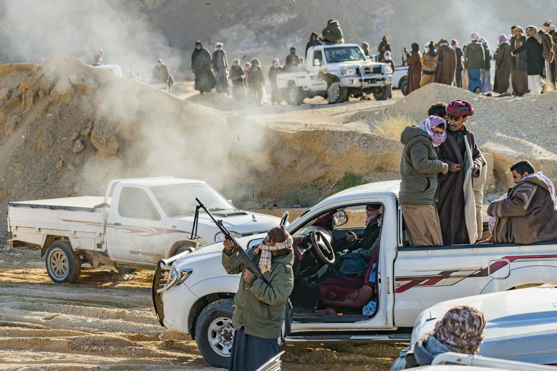 A man celebrates the end of the Wadi Zalaga annual camel race by shooting with a rifle in Sinai, Egypt.