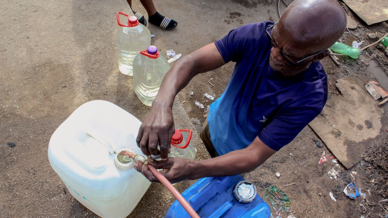 Leonard Matana. 69, filling up a plastic container with water at a communal tap in the township of Kwanobuhle in South Africa. 