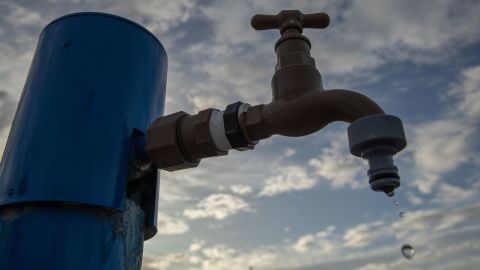 南アフリカ共和国のグケベルハ(Gqeberha)のウォールマー(Walmer)郊外にある水収集地点の蛇口から水が落ちています。 それは都市に設置された多くの収集ゾーンの一つです。