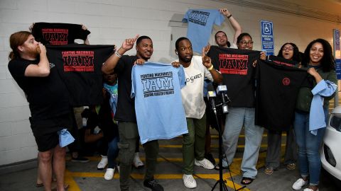 Workers at the Towson Town Center Apple hold their new union t-shirts on June 18, 2022, after their store staff decided to join the International Association of Machinists Union.  It is the first Apple store in the United States to vote for union representation. 