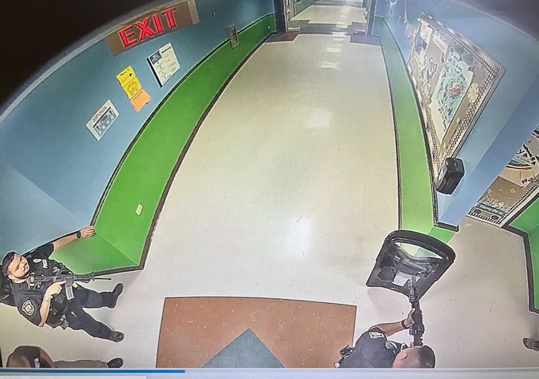 The image, obtained by the Austin-American Statesman, shows at least three officers in the hallway of Robb Elementary at 11:52 a.m, 19 minutes after the gunman entered the school. One officer has what appears to be a tactical shield, and two of the officers hold rifles.