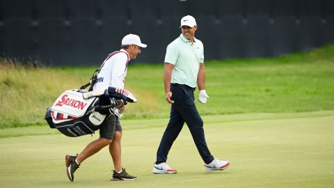 Brooks Koepka of the United States and caddie Ricky Elliott walk the 18th green 
 during the third round of the 122nd U.S. Open Championship at The Country Club on June 18, 2022 in Brookline, Massachusetts.