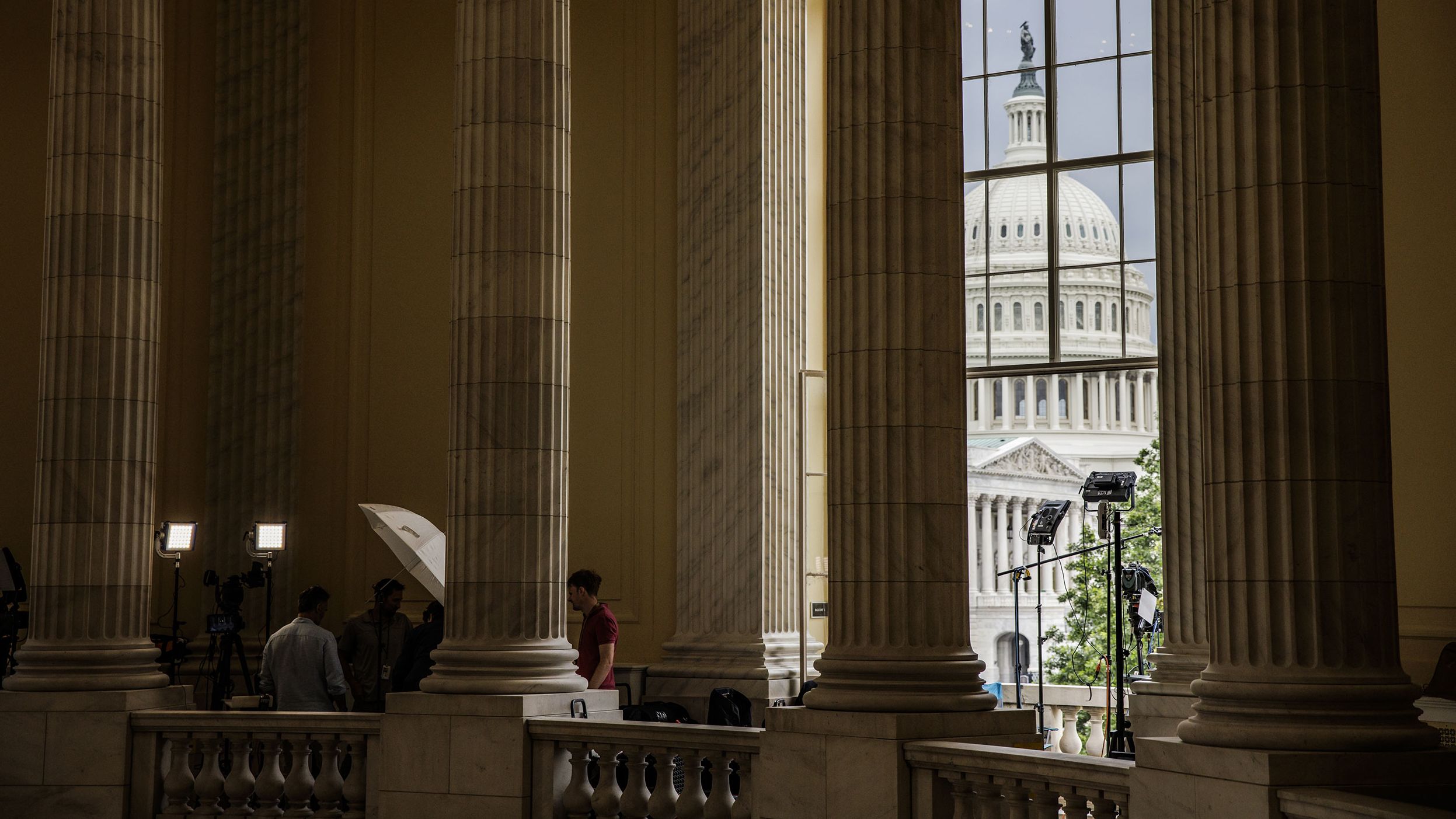 Members of the media work in the rotunda of the Cannon House Office Building outside the hearing on June 21.